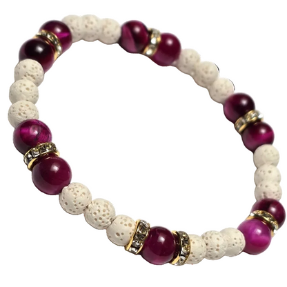 A beaded stretch bracelet featuring glossy deep magenta-purple round beads, textured off-white porous lava stone beads, and gold-toned spacer beads with clear rhinestones, shown on a plain white background.