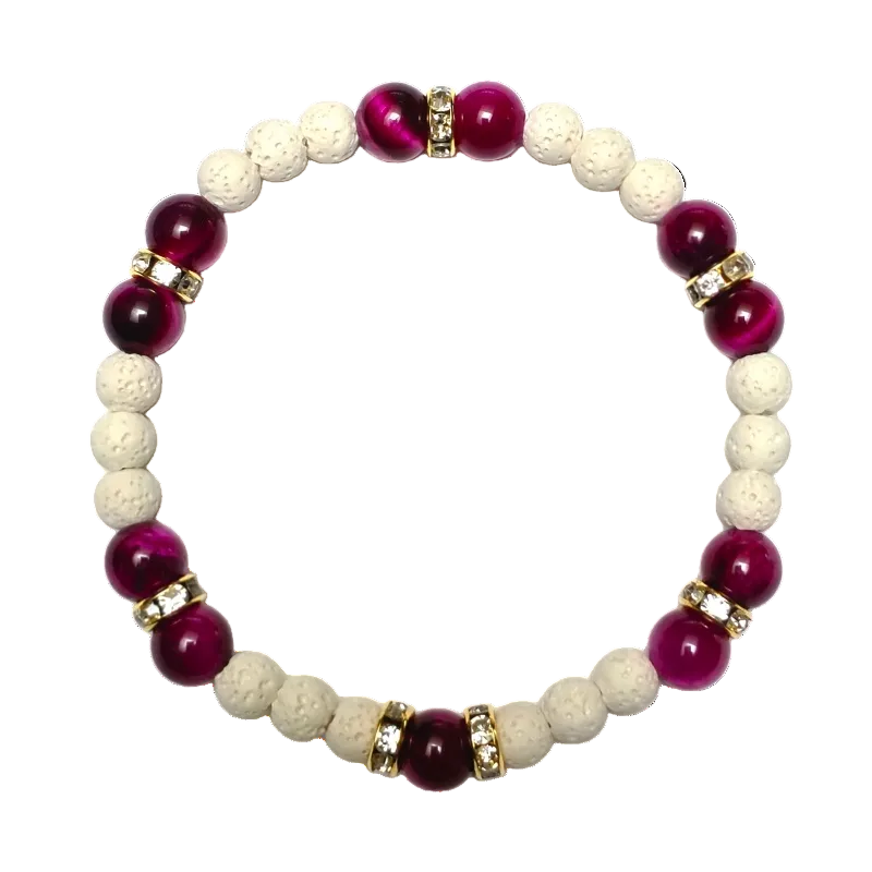A beaded stretch bracelet featuring alternating deep magenta-purple and cream-colored porous beads, accented by small gold spacer rings with clear rhinestones, set against a plain white background.