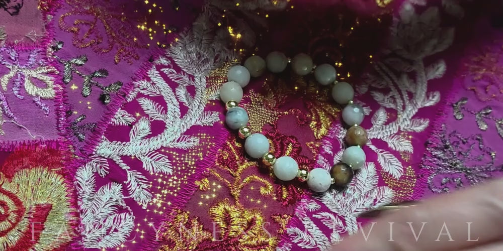 Load video: hands giving reiki to a bracelet with sparkles in the background
