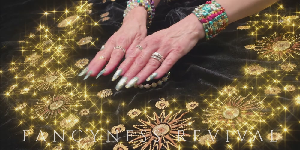 Load video: hands giving reiki to a bracelet with sparkles in the background