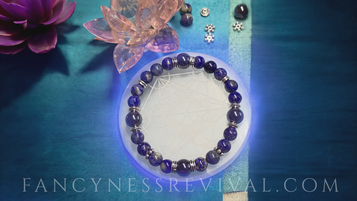 Load video: hands giving reiki to a bracelet with sparkles in the background