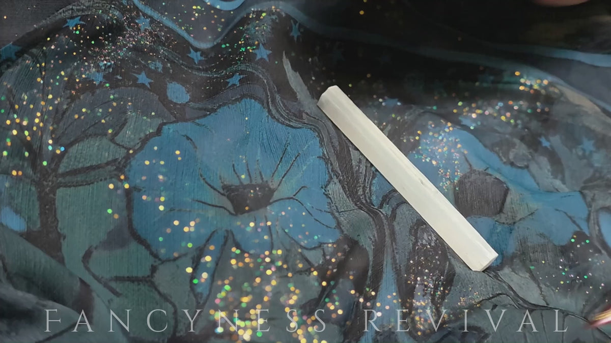 Load video: hands giving reiki to a bracelet with sparkles in the background