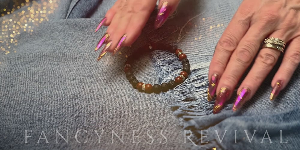 Load video: hands giving reiki to a bracelet with sparkles in the background