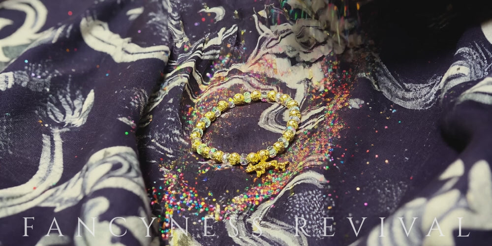 Load video: hands giving reiki to a bracelet with sparkles in the background
