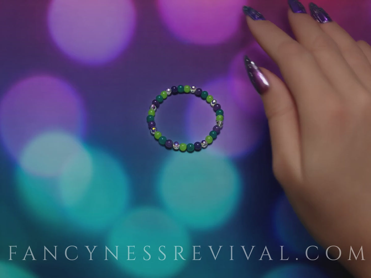 Load video: hands giving reiki to a bracelet with sparkles in the background