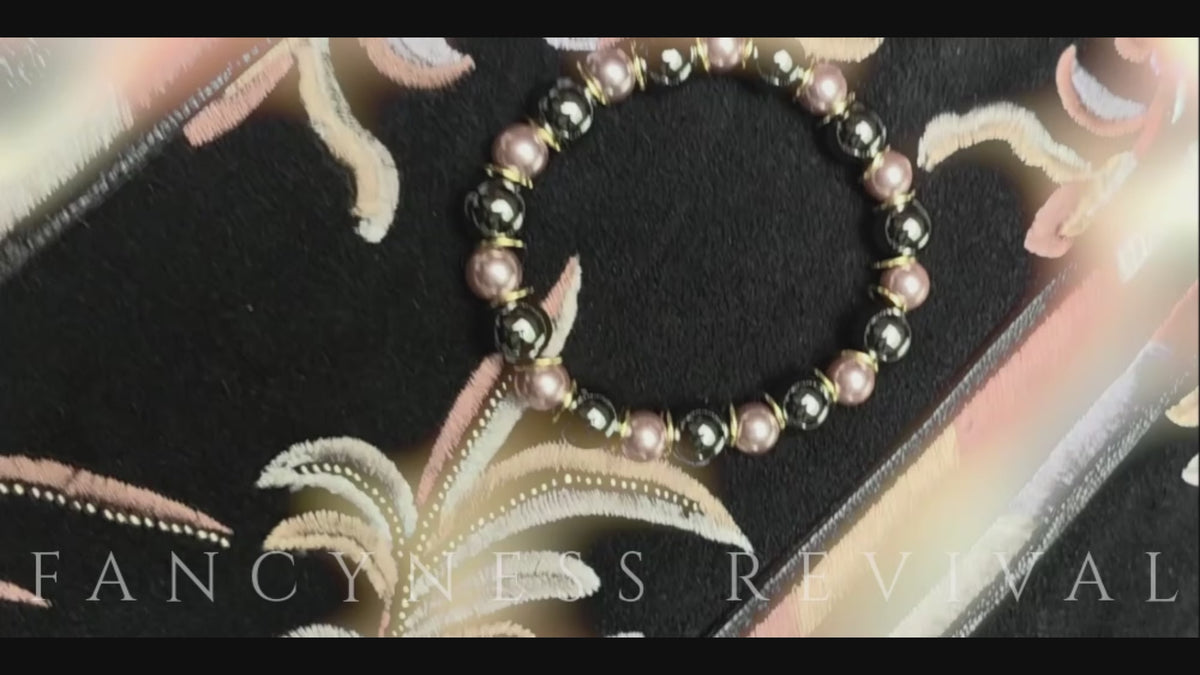 Load video: hands giving reiki to a bracelet with sparkles in the background