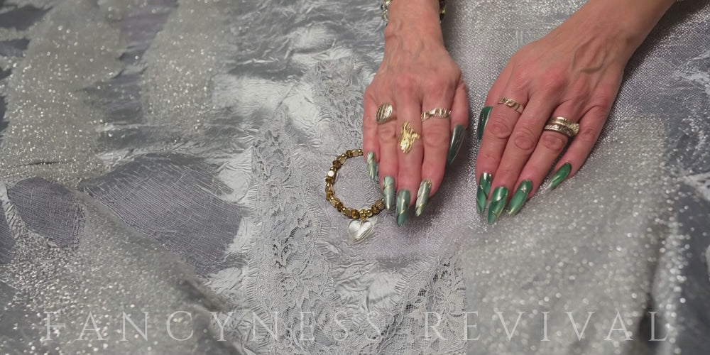 Load video: hands giving reiki to a bracelet with sparkles in the background
